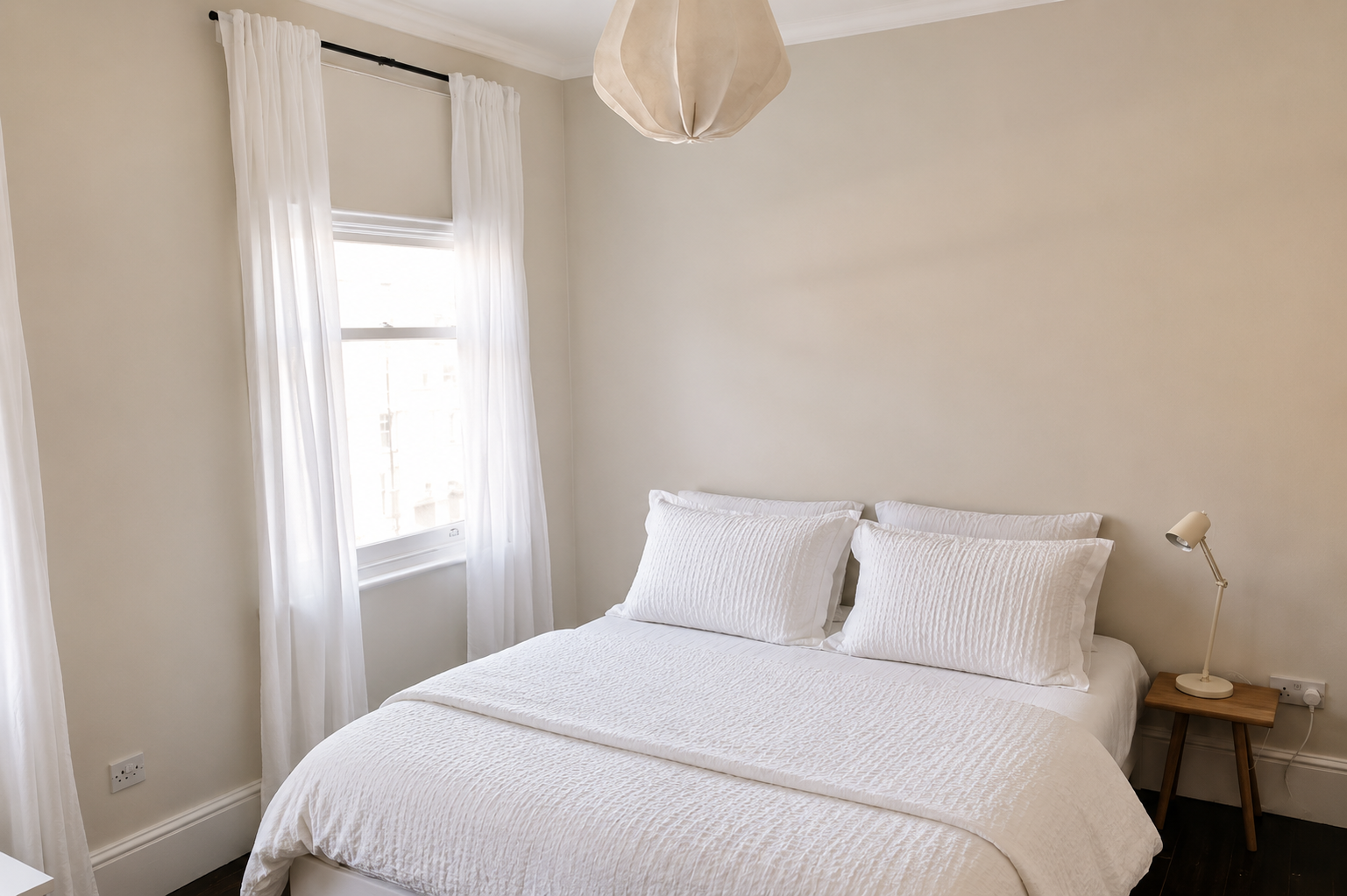 Calm bedroom in the London townhouse with white linen and soft daylight