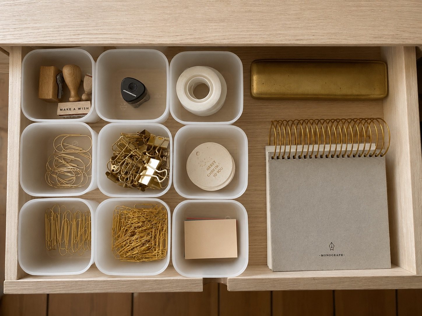 Drawer organised with boxes, stationery and small everyday objects