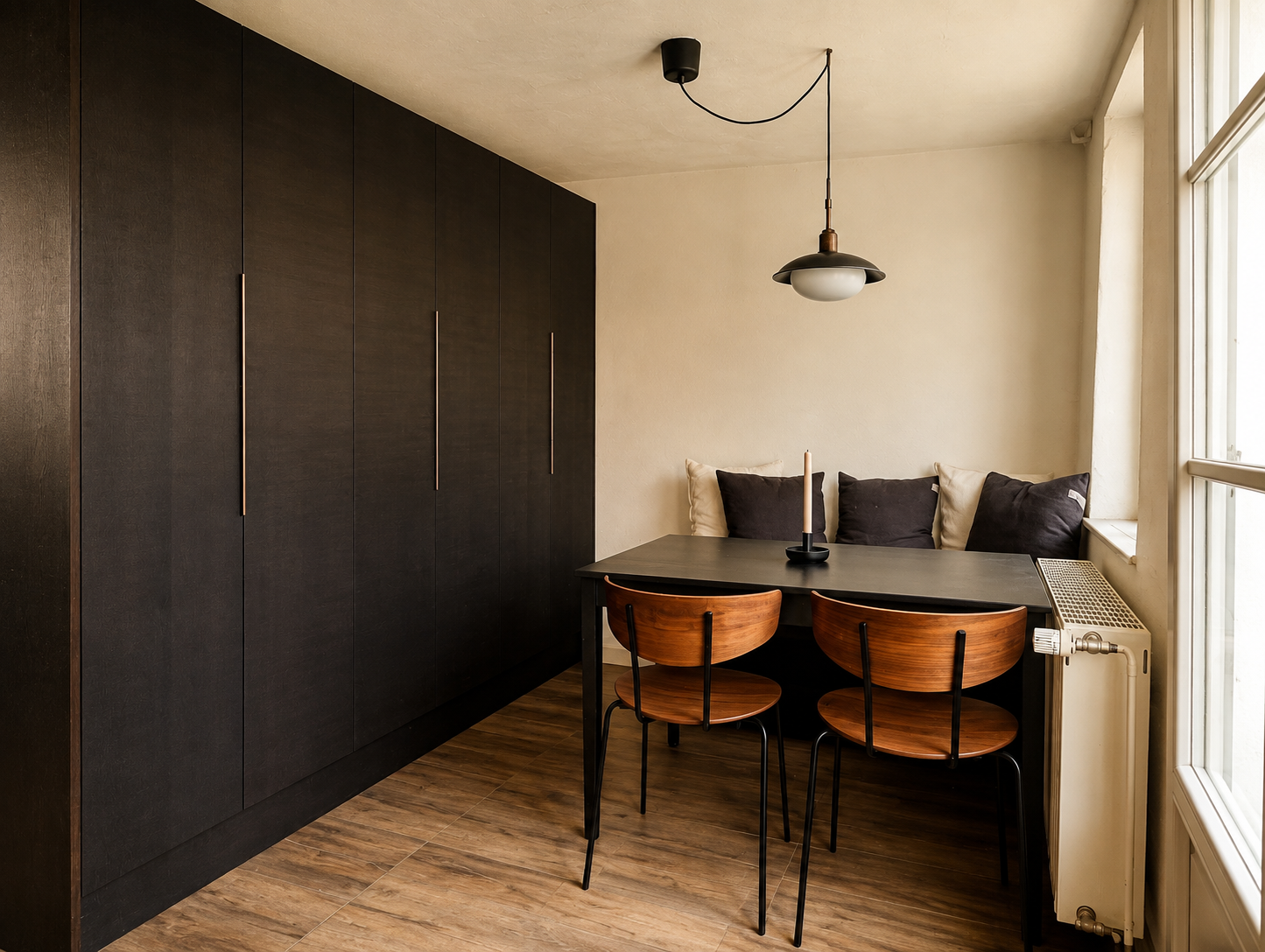 Dining corner in the Brandenburg home with dark cabinetry, timber chairs and window light